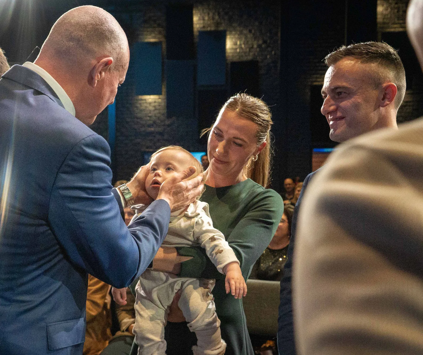 A minister blessing a baby among the people